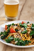 Pasta with Kale, Tomatoes and Walnuts; Sprinkled with Romano Cheese; Glass of Beer