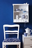 Crockery on Dutch-style kitchen shelving, coffee set on small cabinet and kitchen chair