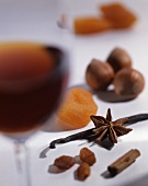 A glass of dessert wine, spices, nuts and dried fruits