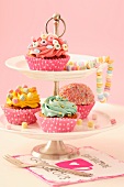 Cupcakes with different decorations on tiered stand