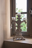 Vintage candlestick on sill of lattice window