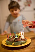 Candles being lit on birthday cupcakes