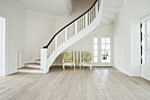 Bright, modern living room with wooden floor, staircase and period furniture