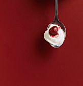Yoghurt and a cherry on a spoon