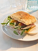 A focaccia sandwich with asparagus, buffalo mozzarella and rocket