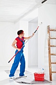 Woman painting wall with roller