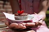 A chocolate cupcake with redcurrants