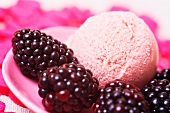 A scoop of blackberry ice cream with fresh blackberries