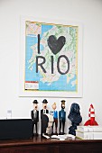 Map with lettering reading 'I love Rio' on wall above collection of comic character figurines