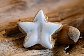 A star-shaped cinnamon biscuit, a hazelnut and a cinnamon stick