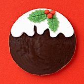 Topped with a Christmas pudding design, on a red surface