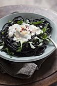 Squid ink spaghetti with rocket, cream sauce and red peppercorns