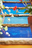 Blau gestrichene Steintreppe mit Topfpflanzen