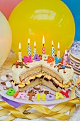 Sponge layer cake with candles for a birthday, and balloons
