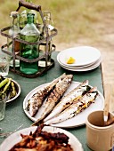 A picnic of barbecued fish, chicken and asparagus, on the beach