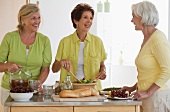 Drei ältere Frauen kochen zusammen
