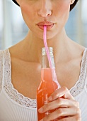 Close up of woman drinking soda from a straw
