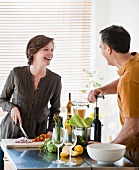 Couple cooking together, woman holding fresh basil