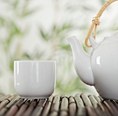 Teapot and cup on bamboo