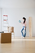 Woman holding paint swatches up to wall