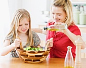 Mother and daughter making salad