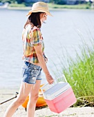 Woman carrying ice chest on beach