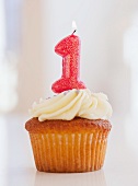 Lit candle on cupcake for first birthday celebration
