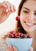 Young woman holding a bowl of cherries