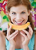 Frau isst ein Stück Cantaloupe-Melone