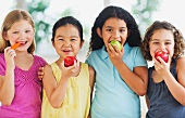 Portrait of girls (6-9) eating fruits