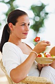 Portrait of young woman eating salad
