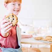 Junge zeigt stolz selbstgebackenen Cookie