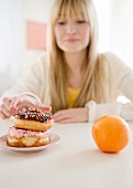 USA, New Jersey, Jersey City, woman reaching for donut