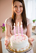 Young woman holding birthday cake