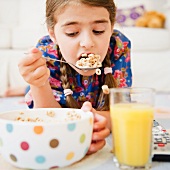 Girl ( 6-7) eating cereals