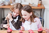 Young girls decorating cupcakes