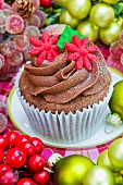 Chocolate cupcake decorated with red sugar flowers for Christmas