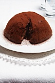 Chocolate bomb cake with cocoa powder, sliced