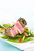 Tuna skewer on a bed of steamed vegetables