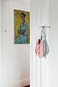 Vintage Handtaschen an Türgriff einer traditionellen Zimmertür aufgehängt und Blick auf Bild an Wand