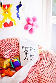 Scatter cushion with cover painted by child on bed in child's bedroom