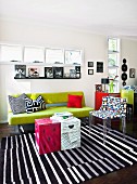 Bright, day-lit, modern living room with ribbon windows; spring green couch, designer chair and original coffee table made from printed cardboard boxes
