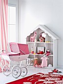 Toys arranged in romantic dolls' house and pink retro dolls' pram