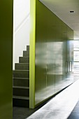 Staircase hidden behind yellow wall with integrated cupboards