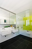 Modernes, weisses Badezimmer mit anthrazitfarbenen Bodenfliesen und einer zitronengelben Wand hinter der Badewanne