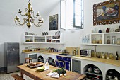 Converted former monastery with barrel vaulted ceiling and masonry kitchen counter; large still-life oil paintings above kitchen shelves