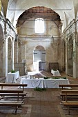 Mit weissen Tischdecken gedeckte, festliche Esstafeln in ehemaligem Kirchenraum eines Klosters