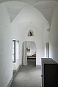 Blick vom Gang ins Schlafzimmer in ehemaligem Kloster; in einer Wandnische eine Madonnenfigur