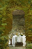 Secluded dining area in stone vaulted room with old church pew