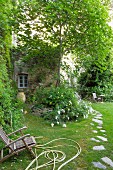 Idyllic garden of former monastery with flagstone path and flowering plants